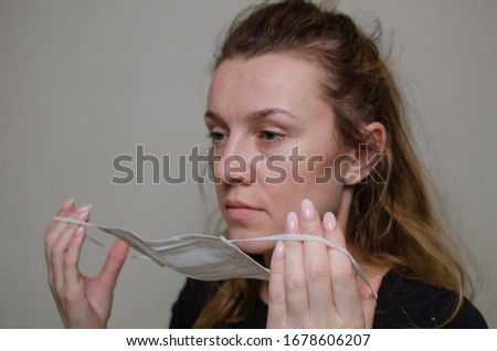 Young woman puts on a medical mask