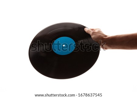 hand holds a vinyl record on a white background