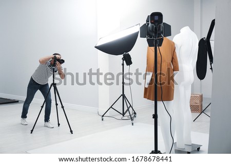 Professional photographer taking picture of ghost mannequin with stylish clothes in modern photo  Royalty-Free Stock Photo #1678678441