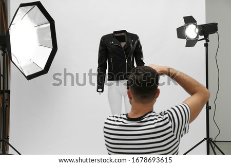 Professional photographer taking picture of ghost mannequin with stylish clothes in modern photo  Royalty-Free Stock Photo #1678693615