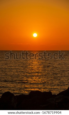 beautiful Sunny sunset on the sea. Amazing summer view on the beach.  blazing sunset landscape at black sea and orange sky above it with awesome sun golden reflection on calm waves. copy space.