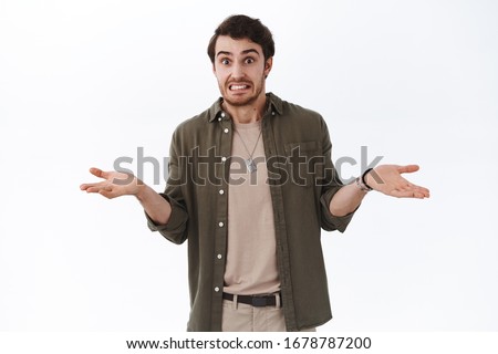 Oops my bad, sorry didnt know. Awkward cute hipster guy saying yikes shrugging and throwing hands indecisive, cant tell, apologizing being guilty, embarrassed for silly mistake, white background Royalty-Free Stock Photo #1678787200