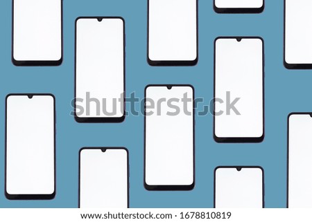Smartphones with a blank screen in a horizontal position on a blue background.