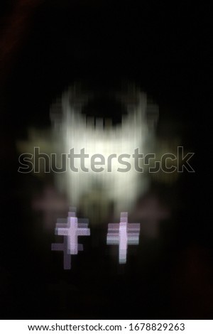multiple white crosses bunched together in a circular formation with a dark background bokeh effect using a special camera lens filter