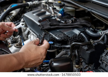 Technician Removing the gasoline  injector part in engine room check dust and test pressure in process maintenance concept Royalty-Free Stock Photo #1678850503