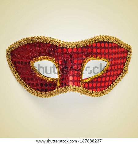 picture of a red and gold carnival mask on a beige background, with a retro effect