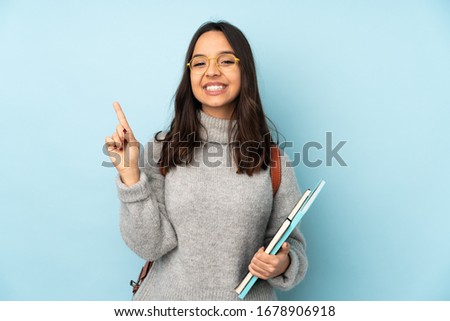 Young mixed race woman going to school isolated on blue background showing and lifting a finger in sign of the best
