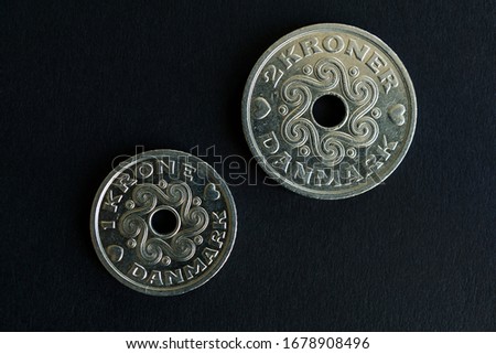 Direct above shot of one and two Danish kroner coins on black background. High resolution photography.