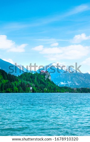 Beautiful and spectacular Julian Alps and Lake Bled. Snow-capped mountain peaks in the background. Church on lake and Castle on the mountain. Slovenia