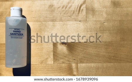 Hand Sanitizer Bottle on Wood Grain Background