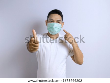 Photo image portrait of young Asian man wearing protective mask against the corona virus covid 19