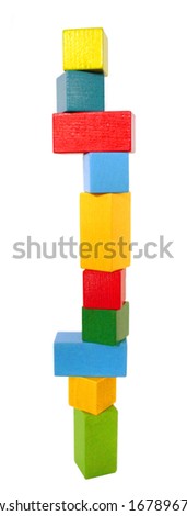 A high colorful block tower of wooden building blocks. Fragile balance. Isolated on a white background. Front view.