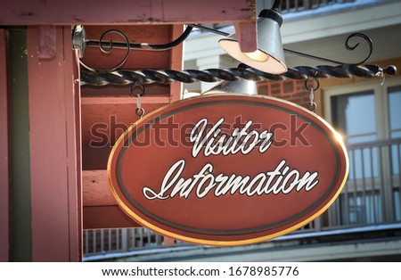 Visitor information sign hanging in metal rod