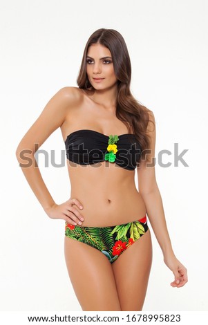 beautiful girl posing in stylish green flower detailed chic black bikini on white background.