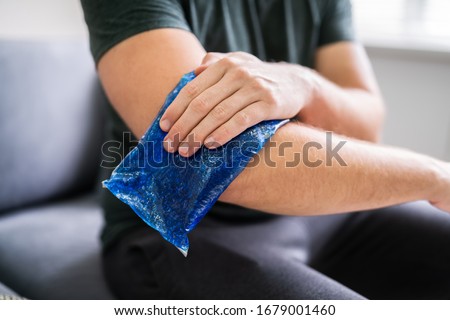Man Using Ice Gel Pack On Injured Arm Royalty-Free Stock Photo #1679001460