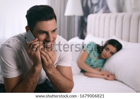 Man preferring talking on phone over spending time with his girlfriend at home. Jealousy in relationship Royalty-Free Stock Photo #1679006821