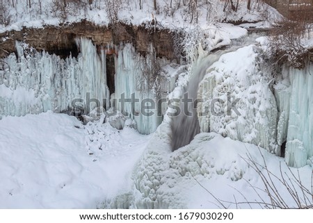 A High Angle Shot on the Minnehaha Falls Nearly Frozen and Under Fresh Snow