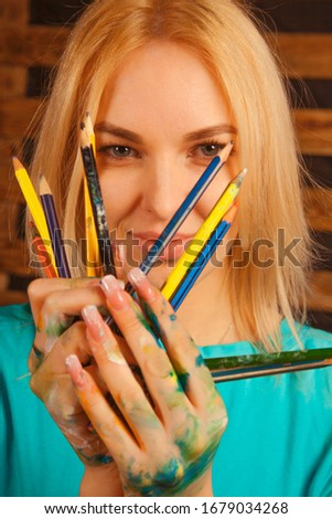 Portrait of beautiful young woman with colored pencils as symbol of art, education and inspiration.
