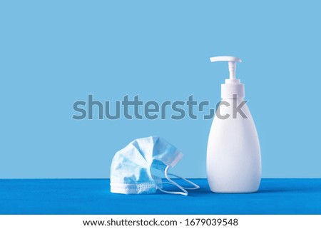 Personal hygiene during the epidemic of influenza, hand disinfector, medical mask on a blue background. Virus, Chinese pandemic coronovirus, panic concept. 2019 ncov.