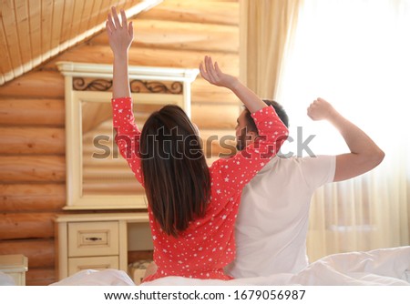 Cute couple stretching in bedroom. Lazy morning