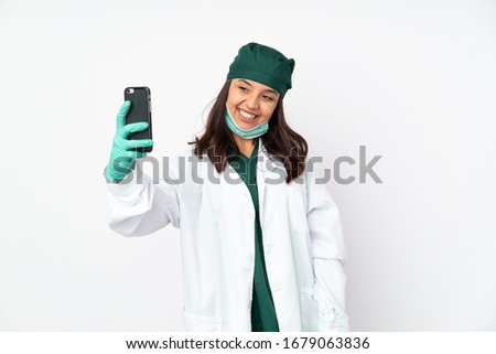 Surgeon woman in green uniform isolated on white background making a selfie