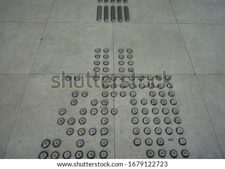 Embossed sign on the floor from silver material to entering toilet as public facilities for blind people in Yogyakarta 