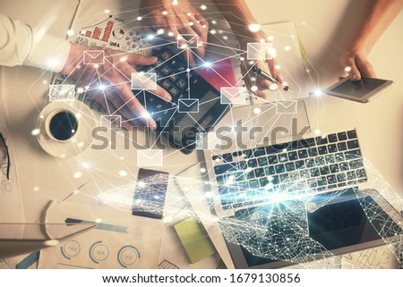 Double exposure of man and woman working together and the envelop hologram drawing. Computer background. Top View. Electronic mail concept.