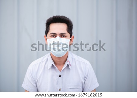 Protect self from virus. Asian man wearing face mask to protect himself from any virus or pollution.  Royalty-Free Stock Photo #1679182015