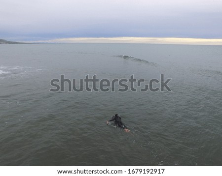 Surfer waiting for wave in ocean, Aerial drone photo
