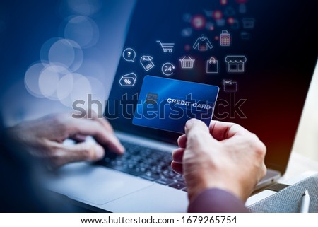 Man's hand holding credit card while using laptop online with shopping illustration icon. Wireless Business Electronic Technology Concept