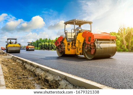 Construction site is laying new asphalt road pavement,road construction workers and road construction machinery scene.highway construction site landscape. Royalty-Free Stock Photo #1679321338