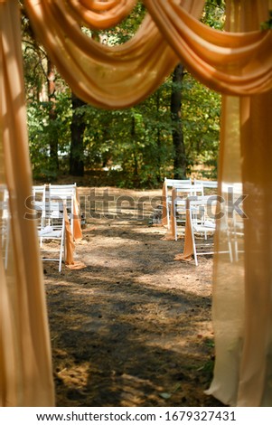 White wooden chairs near altar in park. Concept of celebrating wedding ceremoy outside in forest.