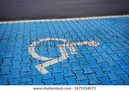 A high angle closeup shot of the handicapped symbol on the blue cobblestone ground