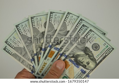 fan of one hundred dollar bills of a new sample in a man's hand, stock photo, white background