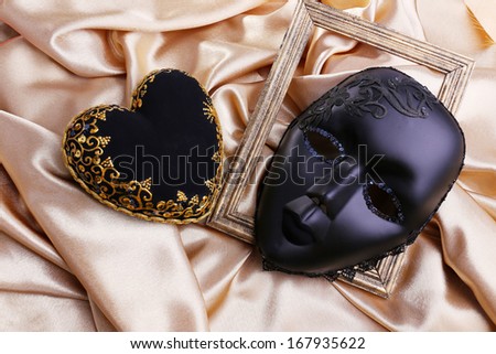 Decorative black heart and mask, on color fabric