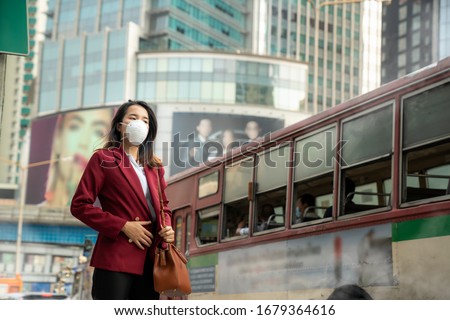 Asian girl use a protection mask for prevent PM 2.5 and corona viruus or covic 19 in park of Bangkok city Royalty-Free Stock Photo #1679364616