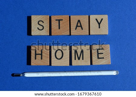 Stay Home, words and mercury thermometer on blue background