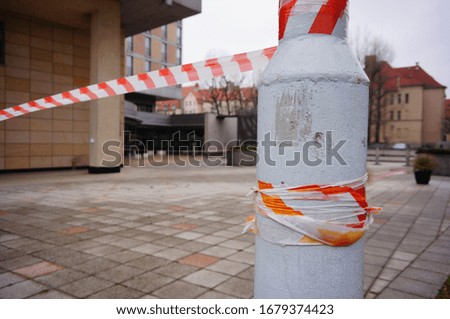 A closeup shot of a red and white warning tape on a white stone column