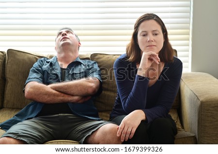 Bored adult couple forced to stay at home as the pandemic coronavirus (COVID-19) forces many people to stay at home because new government policies. Real people. Copy space Royalty-Free Stock Photo #1679399326