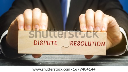 Man holds wooden puzzles with the words Dispute Resolution. Law and justice concept. Litigation, arbitration, mediation. ADR. Search for compromises. Lawyer services Royalty-Free Stock Photo #1679404144