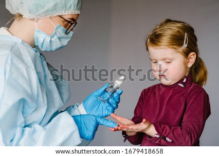 Nurse or doctor use Hand sanitizer alcohol gel rub clean hands child, hygiene prevention of coronavirus virus outbreak. Child using bottle of antibacterial sanitiser soap.