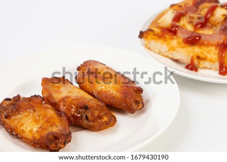 Grilled chicken and pizza on a white plate