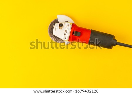 simple black and red angle grinder machine tool isolated against the colorful surface