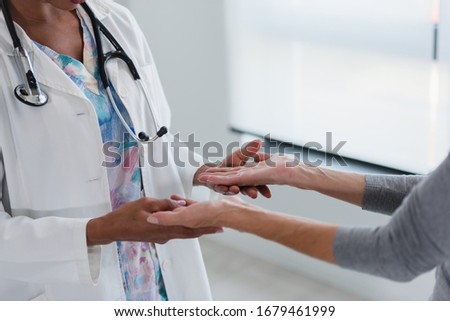 Hands of a doctor holding hands of elderly patient. Checking symptoms of stroke. Medical care and support concept. Royalty-Free Stock Photo #1679461999