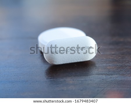 Hydroxychloroquine tablet medication for treatment Malaria, and potential new drug cure for COVID 19 Corona virus closeup. Therapy for Koronavirus. Pharmaceuticals on wooden table Royalty-Free Stock Photo #1679483407