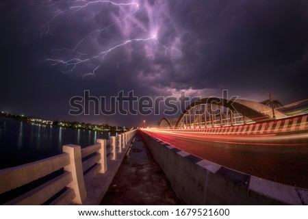 Thunder Lightening in the sky and Light Trails of Vehicle on the road.