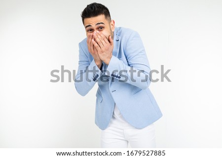 handsome man in classic style laughs covering his mouth with his hand on a white background isolated