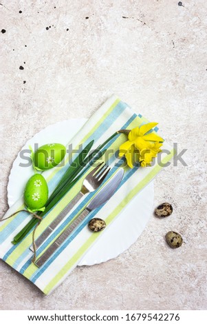 Beautiful festive or Easter table setting with spring flowers and eggs on light textured background. Top view with copy space.