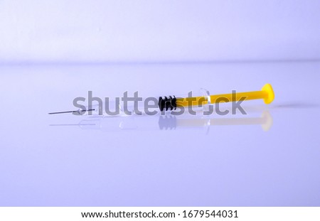 A syringe with a drug solution for injection, with yellow piston.