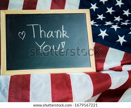 The message Thank you written in a chalkboard or blackboard with United States of America flag. Veteran military or independent day concept.